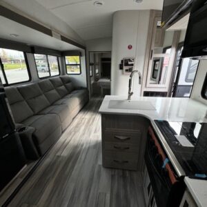 Spacious and modern RV interior with ample seating and kitchen area.