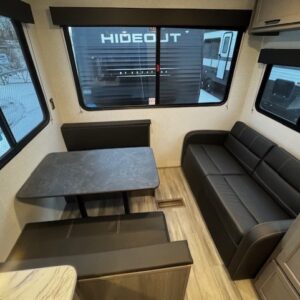 Cozy RV interior with a dining area and sofa seating.