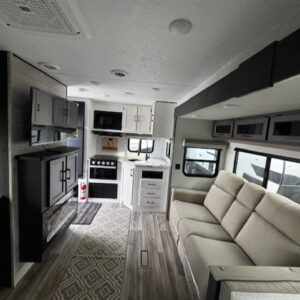 Modern RV interior with kitchen and seating area.