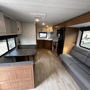 Interior of a modern RV with kitchen and seating area.