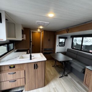 Modern RV interior with kitchen and seating area.