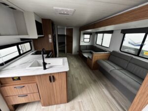 Modern RV interior with kitchen and seating area.