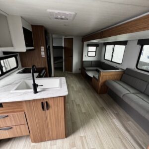 Modern RV interior with kitchen and seating area.